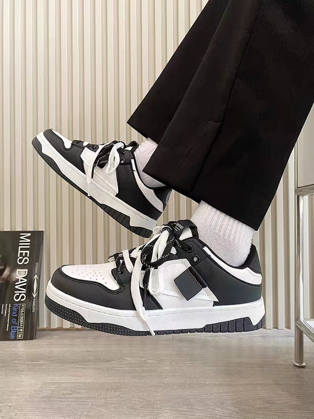 Versatile casual sneakers in black and white with front lace-up design, low top, and rubber soles.