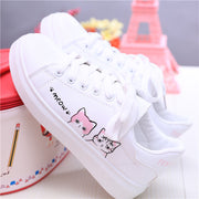 Girls' white leather sneakers with cat design, flat rubber sole, casual style.