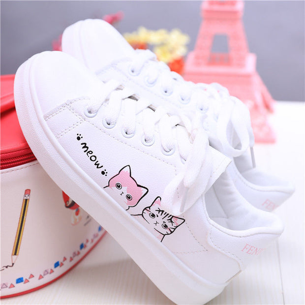 Girls' white leather sneakers with cat design, flat rubber sole, casual style.