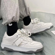 Casual sneakers in white with a low-top design and front lace-up detail, suitable for men and women.