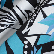 Close-up of black and white geometric pattern with blue accents on a Hawaiian casual streetwear shirt.