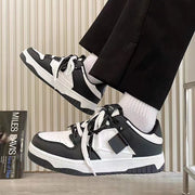 Casual sneakers with black and white leather stitching, round toe, and lace-up front.
