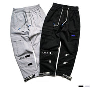 VantageGo streetwear joggers in black and grey cotton fabric with drawstring waist and multiple pockets.