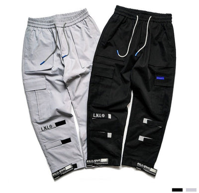 VantageGo streetwear joggers in black and grey cotton fabric with drawstring waist and multiple pockets.