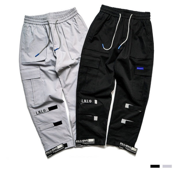 VantageGo streetwear joggers in black and grey cotton fabric with drawstring waist and multiple pockets.