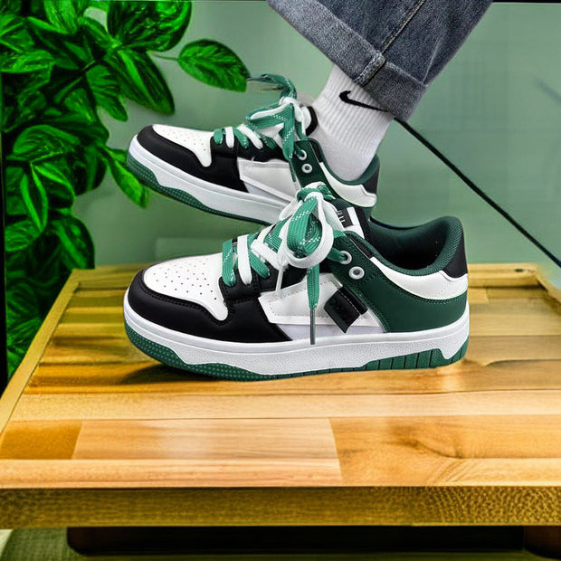 Casual sneakers in black, white, and green with front lace-up design, low top, and rubber sole.