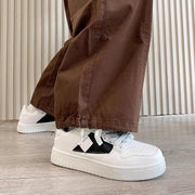 Casual white sneakers with black accents, low-top design, round toe, suitable for all seasons.
